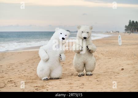 Animateure, die als Eisbären verkleidet sind, unterhalten die Leute am Strand Stockfoto