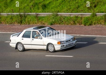 1989 80er Jahre Ford Sierra RS Cosworth White Car Saloon Benzin 1993 ccm; Fahrt mit Geschwindigkeit auf der Autobahn M6 in Greater Manchester, Großbritannien Stockfoto