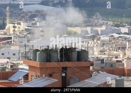 230910 -- BEIRUT, 10. September 2023 -- Scharfschützen der libanesischen Armee auf dem Dach eines Gebäudes mit Blick auf das palästinensische Flüchtlingslager Ain Al-Helweh, als Rauch aus einer Granate in der Nähe von Sidon im Südlibanon aufsteigt, 9. September 2023. Bewaffnete Auseinandersetzungen zwischen Mitgliedern der Fatah-Bewegung und islamischen Militanten im palästinensischen Flüchtlingslager Ain Al-Helweh im Südlibanon intensivierten sich am Samstag, wobei zwei Menschen getötet und elf weitere verletzt wurden, berichtete die nationale Nachrichtenagentur. Die Zusammenstöße führten zu einer neuen Welle der Vertreibung aus dem Lager, als Hunderte von Familien in der Halle der Mosuli-Moschee in der Stadt Sido Zuflucht suchten Stockfoto