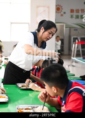 230910 -- HAIKOU, 10. September 2023 -- Fu Yaohui hilft einem Schüler, Haare an der Hainan Haikou Special School in Haikou, südchinesische Provinz Hainan, 6. September 2023 zu kämmen. Fu Yaohui ist Lehrer an der Sonderschule in Haikou. Seit 2004 engagiert sich Fu in Sonderpädagogik für Schüler mit geistiger Behinderung, um ihre Grundfertigkeiten zur Anpassung an das Leben zu entwickeln. Jeden Tag kommt Fu früh in die Schule und begleitet die Schüler mit Geduld und Ermutigung. Ich möchte, dass meine Schüler selbstständig sind, sagte sie. Um dieses Ziel zu erreichen, versucht sie ihr Bestes, diesen Kindern zu helfen Stockfoto