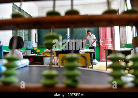 230910 -- GUIDING, 10. September 2023 -- Lu Chengwen 1. R unterrichtet Mathematik für Schüler der ersten Klasse am Yanjiao Teaching Point in Yanshan Township of Guiding County, Provinz Guizhou im Südwesten Chinas, 6. September 2023. Yanjiao Teaching Point ist eine Mikro-Grundschule, die sich in einem flachen Gebiet zwischen Bergen im südwestchinesischen Guizhou befindet. Lu Chengwen ist hier der einzige Lehrer mit 28 Vorschulkindern und 6 Schülern der ersten Klasse. Im Jahr 2012 entschied sich Lu, der gerade seinen Abschluss an der Universität gemacht hatte, am entfernten Yanjiao Teaching Point zu lehren. Vorschulkinder, aufgewachsen aus dem bergigen Dorf der Miao-Ethnie, c Stockfoto