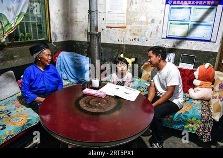 230910 -- GUIDING, 10. September 2023 -- Lu Chengwen 1st R besucht das Haus eines Studenten in der Yanshan Township of Guiding County, südwestchinesische Provinz Guizhou, 6. September 2023. Yanjiao Teaching Point ist eine Mikro-Grundschule, die sich in einem flachen Gebiet zwischen Bergen im südwestchinesischen Guizhou befindet. Lu Chengwen ist hier der einzige Lehrer mit 28 Vorschulkindern und 6 Schülern der ersten Klasse. Im Jahr 2012 entschied sich Lu, der gerade seinen Abschluss an der Universität gemacht hatte, am entfernten Yanjiao Teaching Point zu lehren. Vorschulkinder, die aus dem bergigen Dorf der Miao-Volksgruppe erwachsen sind, konnten kaum Mandarin Chine sprechen Stockfoto