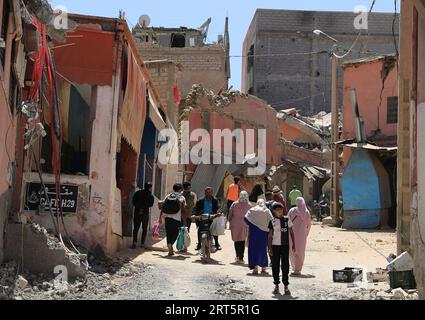 230910 -- MARRAKESCH, 10. September 2023 -- Bewohner passieren beschädigte Gebäude in der Nähe des Epizentrums im Dorf Amizmiz in Marokko, 10. September 2023. Ein Erdbeben der Stärke 6,8 traf Marokko am Freitag. Das Epizentrum des Erdbebens lag in der Nähe der Stadt Ighil in der Provinz Al Haouz, etwa 70 km südwestlich von Marrakesch. Das Beben hat 2.012 Menschen das Leben gekostet und 2.059 verletzt, wobei 1.404 von ihnen in einem ernsten Zustand sind, laut dem neuesten Update des Innenministeriums des Landes am Samstag. MAROKKO-ERDBEBEN-NACHWIRKUNGEN WangxDongzhen PUBLICATIONxNOTxINxCHN Stockfoto