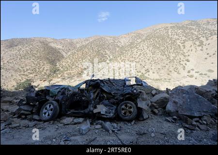 Al Haouz, Marokko. September 2023. Ein durch das Erdbeben schwer beschädigtes Auto wird auf dem Weg zum Dorf Ijjoukak in der Nähe von Marrakesch auf einer Straße zurückgelassen. Al Haouz, Marokko am 10. September 2023. Foto von Youssef Boudlal/ABACAPRESS.COM Credit: Abaca Press/Alamy Live News Stockfoto