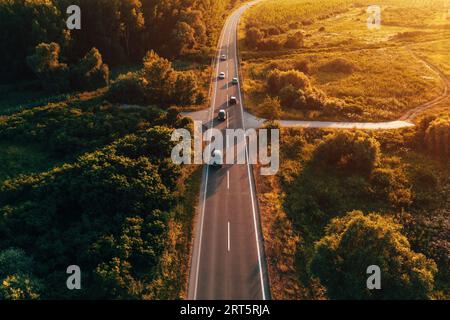 Landstraße mit vielen Autos im Sonnenuntergang, Luftaufnahme aus Drohne pov-Hochwinkel-Ansicht Stockfoto