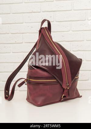 Rucksack aus braunem Leder auf weißem Backsteinhintergrund Stockfoto