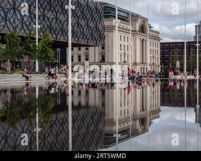 Centenary Square, Birmingham, Großbritannien; Reflexionen der Library of Birmingham und des Baskerville House in einem flachen, ornamentalen Pool. Stockfoto