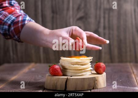 Stapel frisch zubereiteter traditioneller Pfannkuchen mit Erdbeeren. Stockfoto