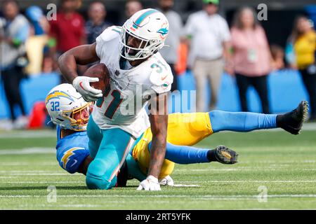 Los Angeles, Usa. September 2023. Miami Dolphins Running Back Raheem Mostert (VORNE) wird von Los Angeles Chargers Safety Alohi Gilman (HINTEN) während eines NFL-Fußballspiels angegriffen. Miami Dolphins 36:34 Los Angeles Chargers (Foto: Ringo Chiu/SOPA Images/SIPA USA) Credit: SIPA USA/Alamy Live News Stockfoto