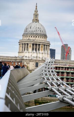 LONDON - 24. April 2023: St Paul's Cathedral, eingerahmt von der Millenniums Bridge und einem entfernten roten Baukran in einem einzigartigen Stadtblick. Stockfoto