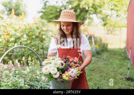 Eine 30-jährige Frau, die sich ihren Blumenstrauß mit frisch geschnittenen Blüten anschaut Stockfoto