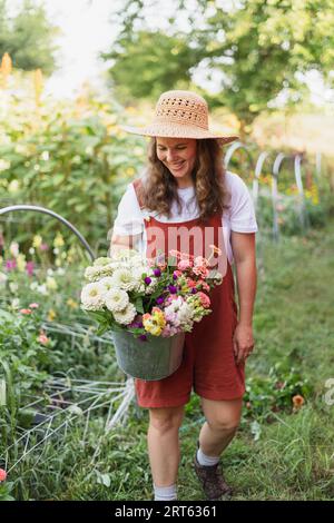Eine Frau, die einen Blumenstrauß aus ihrer Schnittblume trägt Stockfoto