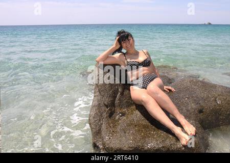 Alte Frau im Bikini auf den Felsen Stockfoto