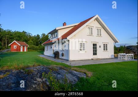 Ein früher Morgen in einem Ferienhaus mit einem Gebäude im traditionellen Stil auf der Insel Buholmen im Kragero-Archipel, Telemark, Norwegen. Stockfoto