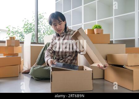 Asiatische Männer packen in den Kasten, um nach Hause zu ziehen. Die Idee, das Haus zu verlegen Stockfoto