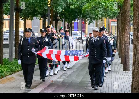 New York, USA. September 2023. Ehrenwachen tragen eine US-Flagge, wenn sie zum National September 11 Memorial in Downtown Manhattan kommen, um die Gedenkfeier zum 22. Jahrestag der Angriffe vom 11. September zu feiern. Quelle: Enrique Shore/Alamy Live News Stockfoto