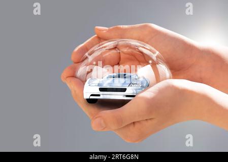 Ein Mann, der ein Auto in den Händen hält - ein Versicherungskonzept Stockfoto