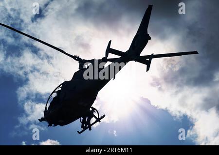 Silhouette eines Kampfhubschraubers am Himmel, Gazelle von unten gesehen, Lufttransport Stockfoto