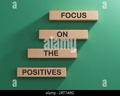 Konzentrieren Sie sich auf das positive Symbol. Konzeptworte konzentrieren sich auf die positiven Aspekte von Holzblöcken. Geschäftskonzept. Kopieren Sie Space.3D-Rendering auf grünem Hintergrund. Stockfoto