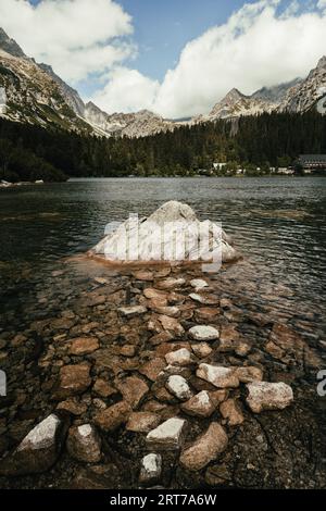Foto eines wunderschönen Sees mit kristallklarem Wasser in der Hohen Tatra - Slowakei. Vertikale Aufnahme von Popradske pleso mit riesigen Bergen und Wald o Stockfoto