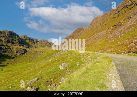 Applecross Bealach na Ba einspurige Straße durch die Berge und ein rotes Auto auf der Straße Stockfoto