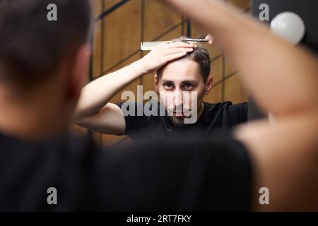 Der Friseur schneidet sich die Haare selbst. Stockfoto