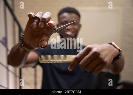 Der Friseur hält ein Arbeitsgerät in den Händen Stockfoto