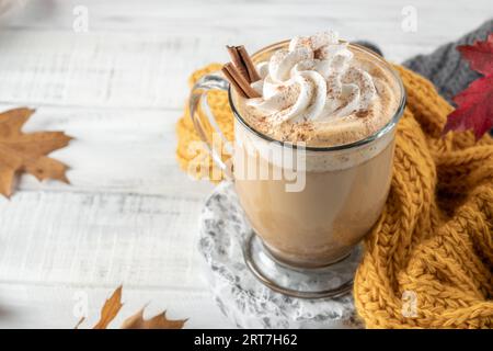 Kürbis-Gewürz-Latte in einem Glaskrug mit Zimt mit Herbstdeko Stockfoto