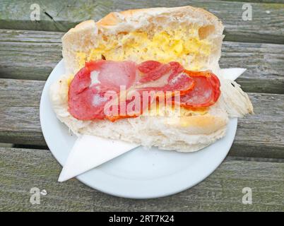 Mittags Snack auf einem Außentisch Bacon in einem weichen weißen Rolle Stockfoto