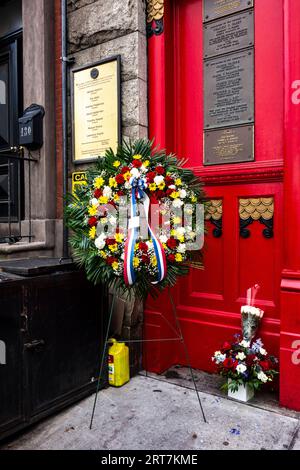 Erinnerung an das Jahr 9/11 mit Blumen vor der Liste der Feuerwehrmänner, die am Feuerwehrhaus 9/11 Squad 18 in der 10th St, Greenwich Village, New York City, NY, verloren gegangen sind Stockfoto