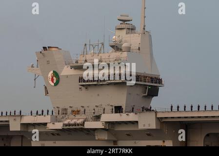 Portsmouth, England, Großbritannien. 8. September 2023. Die HMS Queen Elizabeth verlässt den Hafen von Portsmouth in der Abenddämmerung mit Offizieren, Geschützen und Crew-Mitgliedern, die den säumen Stockfoto