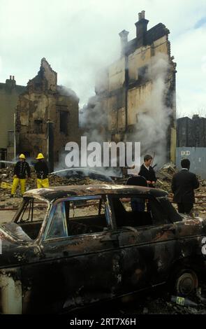 In Brixton herrscht ein Aufstand der 1980er Jahre in Großbritannien. Am Tag nach der Feuerwehr stellte die Feuerwehr sicher, dass die brennenden Gebäude vollständig sicher sind. Ausgebranntes zerstörtes Gebäude entführt Burnout Auto. Brixton South London Großbritannien April 1981 England HOMER SYKES. Stockfoto