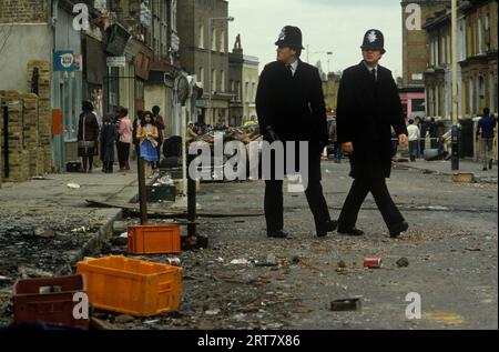 Brixton-Unruhen. South London, Großbritannien, April 1981. Die Polizei ist am Tag nach dem Tag im Einsatz, an dem die Menschen vor Ort die Schäden in ihrer Nachbarschaft sehen. 1980er Jahre England HOMER SYKES Stockfoto