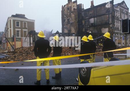 Brixton stößt in den 1980er Jahren auf Großbritannien auf. Am Tag nach der Feuerwehrauto, um sicherzustellen, dass die brennenden Gebäude völlig sicher sind. Verbrannte zerstörte Gebäude, entführte Burnout-Auto. Brixton South London Großbritannien April 1981 England HOMER SYKES. Stockfoto