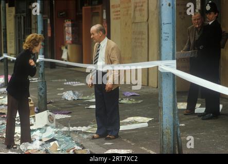 Brixton stößt in den 1980er Jahren auf Großbritannien auf. Am Tag nach der Reinigung nach einer Nacht der Plünderung. Die Ladenbesitzer überwachen den abgesperrten Bereich, sie werden den Schaden an ihrem Eigentum aufräumen, überprüfen und überwachen. Brixton South London Großbritannien April 1981 England HOMER SYKES. Stockfoto