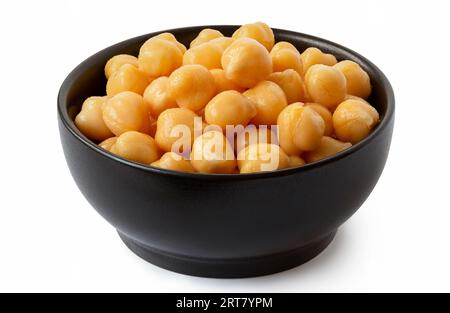 Gekochte Erbsen in einer schwarzen, auf Weiß isolierten Keramikschale. Stockfoto