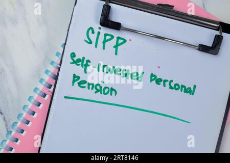 Konzept von SIPP - Selbstinvestierte persönliche Pension Schreiben Sie auf Papiere isoliert auf Holztisch. Stockfoto