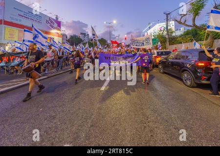 Haifa, Israel - 9. September 2023: Menschen marschieren mit verschiedenen Schildern und Flaggen. Woche 36 des Protestes gegen eine umstrittene Justizreform. Haifa, Isra Stockfoto