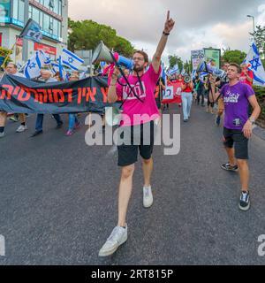 Haifa, Israel - 9. September 2023: Die Menschen marschieren mit verschiedenen Zeichen und Fahnen, angeführt von einem Banner zur Unterstützung des Obersten Gerichtshofs. Woche 36 des Protestes gegen Forts Stockfoto