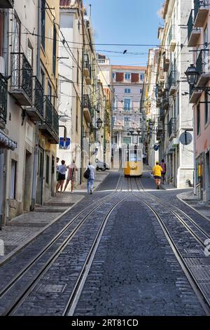 Standseilbahn, gelbe Straßenbahn, Elevador da Bica, Nationaldenkmal, alte Wohngebäude, Fußgänger in engen Gassen, Bairro Alto, Lissabon Stockfoto