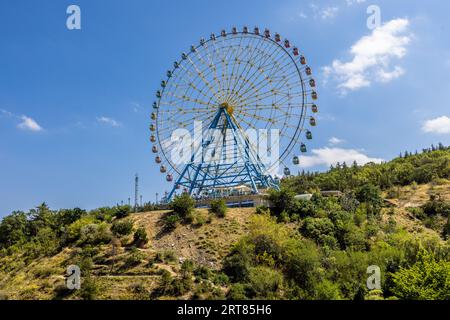 Ein Riesenrad steht auf einem Hügel. Sie befindet sich in Tiflis, Georgien Stockfoto