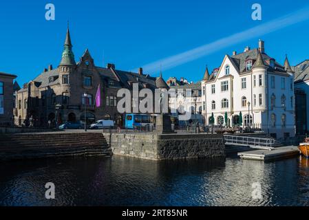 Schöne alte Steinhäuser mit Jugendstilfassaden direkt am Wasser an der Apotekergata in Alesund an einem klaren sonnigen Wintertag Stockfoto