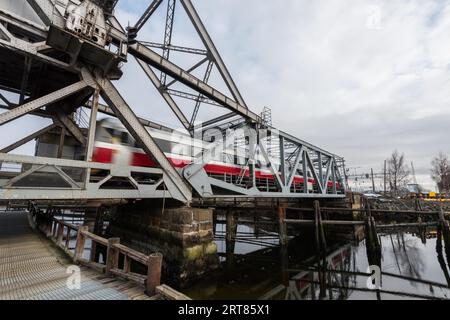 Die Hebebrücke Skansen jernbanebru im Hafen von Trondheim Mit beweglichen verschwommenen Zug vorbei es am bewölkten Wintertag Stockfoto