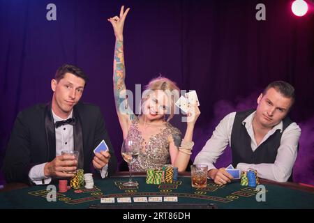 Eine Gruppe junger wohlhabender Freunde spielt Poker in einem Casino. Stockfoto