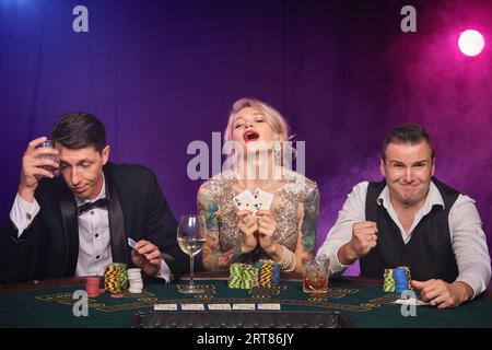 Eine Gruppe junger wohlhabender Freunde spielt Poker in einem Casino. Stockfoto