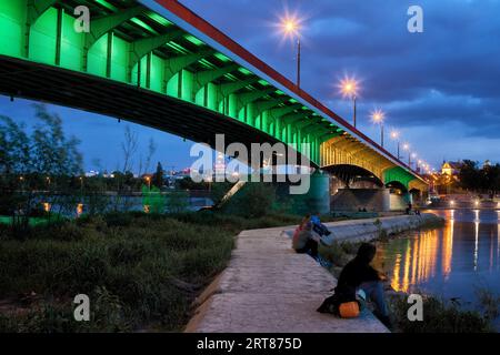 Polen, Warschau, beleuchtete Slasko-Dabrowski Brücke und Pier an der Weichsel in der Abenddämmerung Stockfoto