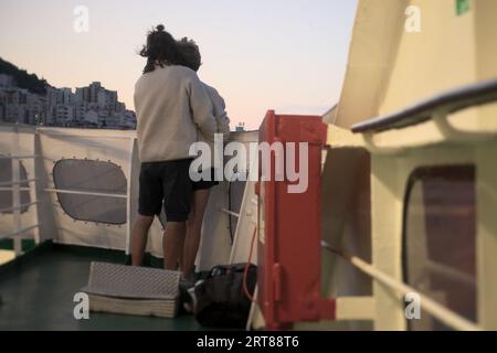 Ein paar Rucksacktouristen freuen sich auf die Fähre, die am Morgen im Urlaubsziel Dubrovnik, Kroatien, ankommt Stockfoto