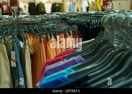 Moderne einfarbige Kleidung - Hosen und Pullover, auf einem Kleiderbügel im Laden. Selektives Schärfen. Stockfoto