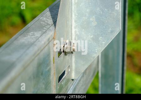 Metallstrukturen werden mit einer Schraube verschraubt. Nahaufnahme der Metallmutter. Stockfoto