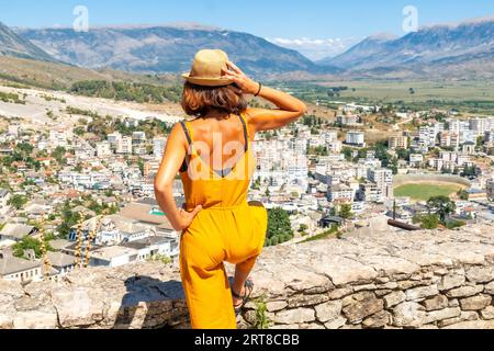 Eine Touristenfrau, die die Stadt von der osmanischen Festung Gjirokaster oder Gjirokastra aus betrachtet. Albanisch Stockfoto